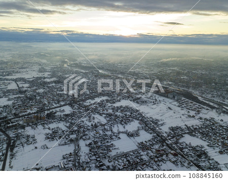 Top view of city suburbs or small town nice houses on winter morning on cloudy sky background. Aerial drone photography concept. 108845160