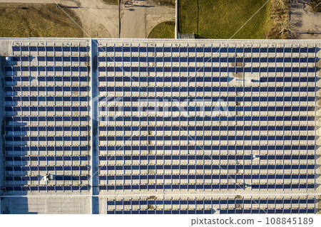 Top view of blue shiny solar photo voltaic panels system producing renewable clean energy abstract background. Top view of blue shiny solar photo voltaic panels system producing renewable clean energy abstract background. 108845189