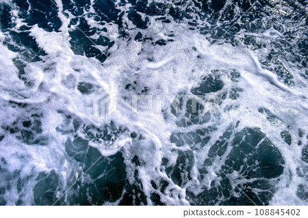 Top down aerial view of sea water surface. White foam waves texture as natural background. Top down aerial view of sea water surface. White foam waves texture as natural background. 108845402
