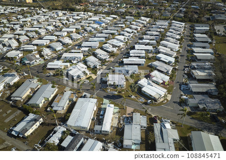 Severely damaged houses after hurricane Ian in Florida mobile home residential area. Consequences of natural disaster 108845471