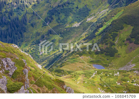 Panorama of Carpathian mountains in summer sunny day. Mountain lake Panorama of Carpathian mountains in summer sunny day. Mountain lake 108845709