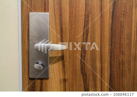 Modren style door handle on natural wooden door. 108846117