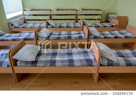 Many small beds in daycare preeschool empty bedroom. Many small beds in daycare preeschool empty bedroom. 108846150