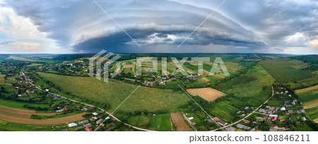 Landscape of dark clouds forming on stormy sky during thunderstorm over rural area. 108846211