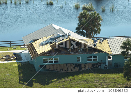 Hurricane Ian destroyed house roof in Florida residential area. Natural disaster and its consequences Hurricane Ian destroyed house roof in Florida residential area. Natural disaster and its consequences 108846283