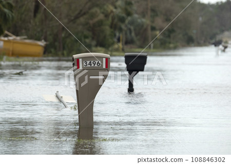 Hurricane flooded street with mail box surrounded with water in Florida residential area. Consequences of natural disaster Hurricane flooded street with mail box surrounded with water in Florida residential area. Consequences of natural disaster 108846302