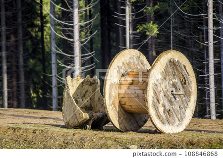 Empty wooden roll that is used for electrical wires and excavator shovel Empty wooden roll that is used for electrical wires and excavator shovel 108846868
