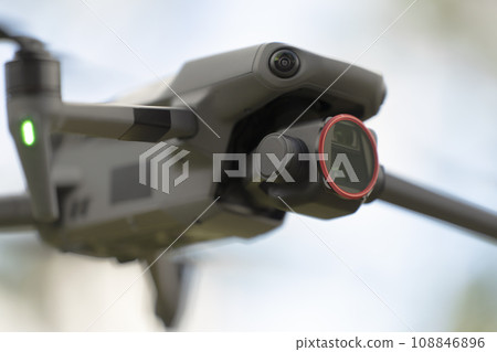 Drone aircraft with blurred fast rotating propellers and video camera flying in air 108846896