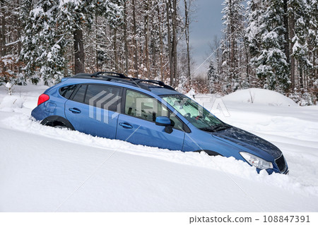 Car stuck in deep snow on cold winter day 108847391