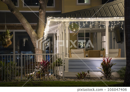 Brightly illuminated christmas decorations on front yard porch of florida family home. Outside decor for winter holidays Brightly illuminated christmas decorations on front yard porch of florida family home. Outside decor for winter holidays 108847406
