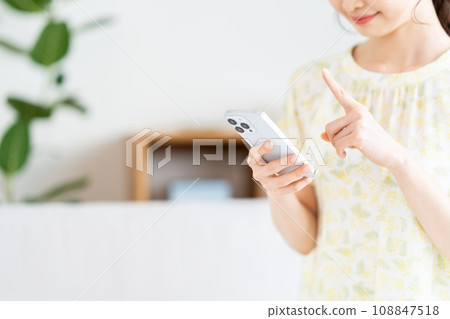 正在操作智慧型手機的女士。 正在操作智慧型手機的女士。 108847518