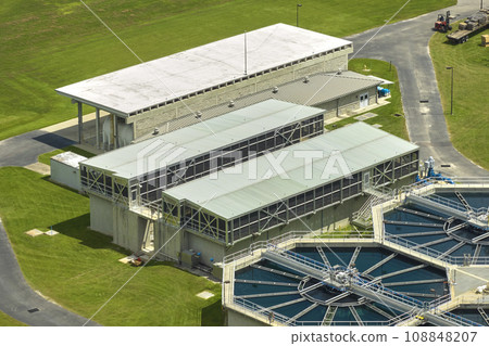 Aerial view of modern water cleaning facility at urban wastewater treatment plant. Purification process of removing undesirable chemicals, suspended solids and gases from contaminated liquid Aerial view of modern water cleaning facility at urban wastewater treatment plant. Purification process of removing undesirable chemicals, suspended solids and gases from contaminated liquid 108848207