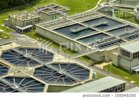 Aerial view of modern water cleaning facility at urban wastewater treatment plant. Purification process of removing undesirable chemicals, suspended solids and gases from contaminated liquid Aerial view of modern water cleaning facility at urban wastewater treatment plant. Purification process of removing undesirable chemicals, suspended solids and gases from contaminated liquid 108848208