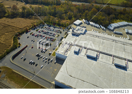 Aerial view of many employee cars parked on parking lot in front of industrial factory building Aerial view of many employee cars parked on parking lot in front of industrial factory building 108848213