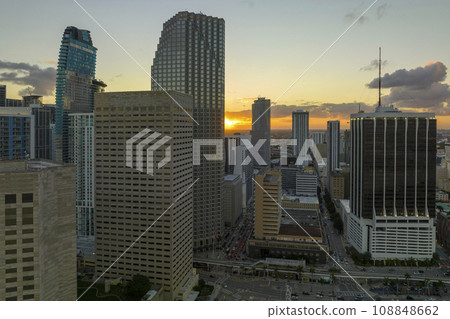 Aerial view of downtown district of of Miami Brickell in Florida, USA at sunset. High skyscraper buildings and street with cars and Metrorail traffic in modern american midtown 108848662