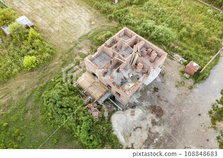 Aerial view of building site for future house, brick basement floor and stacks of brick for construction. 108848683