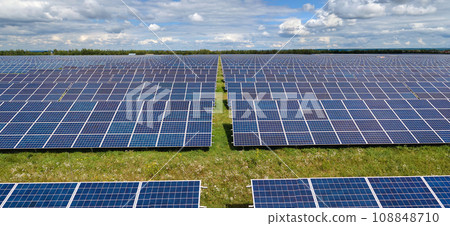 Aerial view of big sustainable electric power plant with many rows of solar photovoltaic panels for producing clean electrical energy. Renewable electricity with zero emission concept Aerial view of big sustainable electric power plant with many rows of solar photovoltaic panels for producing clean electrical energy. Renewable electricity with zero emission concept 108848710