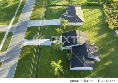 Aerial view of american small town in Florida with private homes between green palm trees and suburban streets in quiet residential area 108848722