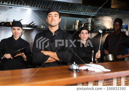 Team of chefs posing in restaurant kitchen Team of chefs posing in restaurant kitchen 108852392