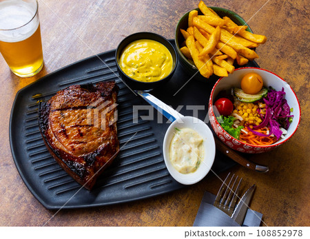 Popular dish of Belgian cuisine is a pork chop according to an old recipe in sauce in Orval 108852978