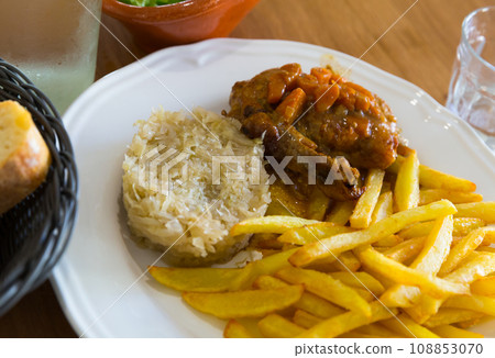 Fried potatoes, sauerkraut, stewed chicken 108853070