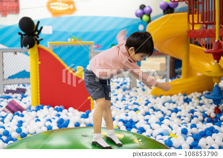 Little boy practices standing on a big inflatable ball. Little boy practices standing on a big inflatable ball. 108853790