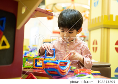 A little Asian boy is playing with a square magnetic puzzle. A little Asian boy is playing with a square magnetic puzzle. 108853805