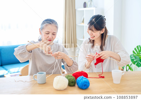 Senior woman and young woman knitting Senior woman and young woman knitting 108853897