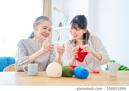 Senior woman and young woman knitting Senior woman and young woman knitting 108853899