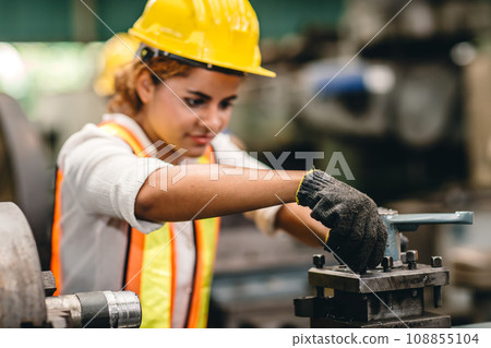 Engineer milling technician African woman worker manual hand skill working in heavy industry control metal lathe machine 108855104