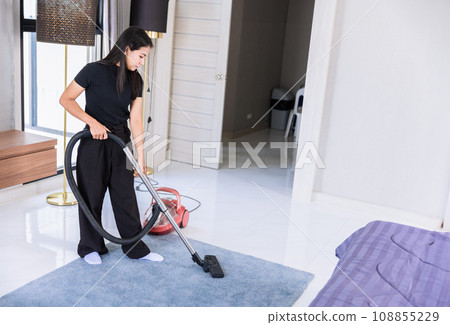 Woman maid home cleaning doing chore, House wife vacuum clean up dust floor carpet in bedroom. 108855229