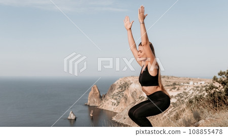 Fitness woman sea. Outdoor workout on yoga mat in park near to ocean beach. Female fitness pilates yoga routine concept. Healthy lifestyle. Happy fit woman exercising with rubber band in park. 108855478