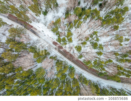 Flight over the winter mountains with road serpentine and pine forest. Top down view. Landscape photography 108855686