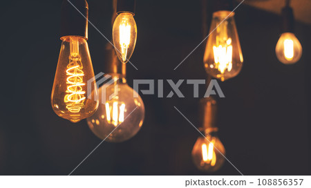 Retro LED light bulbs hanging on a dark background in interior. Electricity, Vintage 108856357