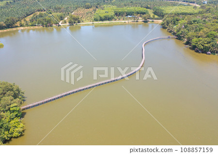Aerial top view of a bridge with garden park with green mangrove forest trees, river, pond or lake. Nature landscape background, Thailand. Aerial top view of a bridge with garden park with green mangrove forest trees, river, pond or lake. Nature landscape background, Thailand. 108857159