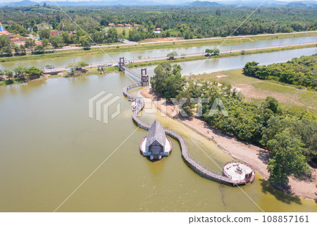 Aerial top view of a bridge with garden park with green mangrove forest trees, river, pond or lake. Nature landscape background, Thailand. 108857161