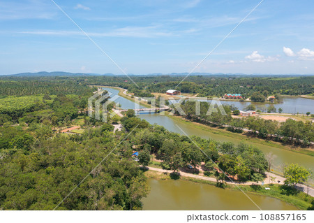 Aerial top view of a bridge with garden park with green mangrove forest trees, river, pond or lake. Nature landscape background, Thailand. Aerial top view of a bridge with garden park with green mangrove forest trees, river, pond or lake. Nature landscape background, Thailand. 108857165