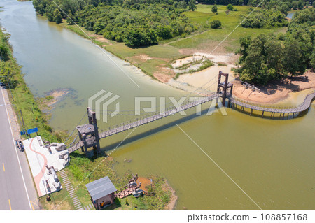 Aerial top view of a bridge with garden park with green mangrove forest trees, river, pond or lake. Nature landscape background, Thailand. Aerial top view of a bridge with garden park with green mangrove forest trees, river, pond or lake. Nature landscape background, Thailand. 108857168