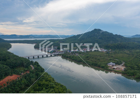 Aerial top view of a bridge with garden park with green mangrove forest trees, river, pond or lake. Nature landscape background, Thailand. Aerial top view of a bridge with garden park with green mangrove forest trees, river, pond or lake. Nature landscape background, Thailand. 108857171