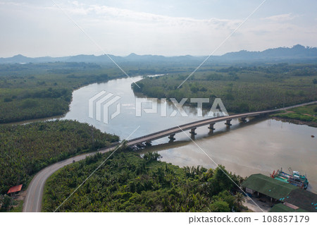 Aerial top view of a bridge with garden park with green mangrove forest trees, river, pond or lake. Nature landscape background, Thailand. Aerial top view of a bridge with garden park with green mangrove forest trees, river, pond or lake. Nature landscape background, Thailand. 108857179