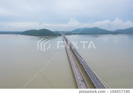 Aerial top view of a bridge with garden park with green mangrove forest trees, river, pond or lake. Nature landscape background, Thailand. Aerial top view of a bridge with garden park with green mangrove forest trees, river, pond or lake. Nature landscape background, Thailand. 108857190