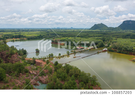 Aerial top view of a bridge with garden park with green mangrove forest trees, river, pond or lake. Nature landscape background, Thailand. Aerial top view of a bridge with garden park with green mangrove forest trees, river, pond or lake. Nature landscape background, Thailand. 108857203