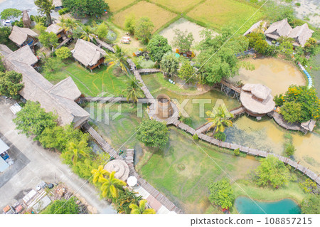 Aerial top view of a bridge with garden park with green mangrove forest trees, river, pond or lake. Nature landscape background, Thailand. 108857215