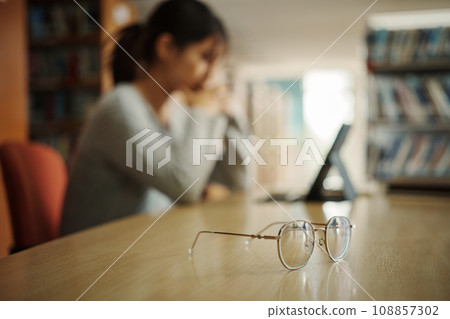 Asian student woman read books in library at university. Young girl stress tired have problem while study hard. Sadness concept 108857302