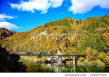 Tadami Line Kiha E120 train crossing the fourth Tadami River Bridge in autumn (Kanayama Town, Fukushima Prefecture, afternoon in late October) Tadami Line Kiha E120 train crossing the fourth Tadami River Bridge in autumn (Kanayama Town, Fukushima Prefecture, afternoon in late October) 108857504
