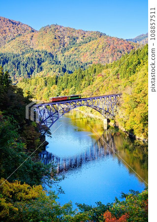 Tadami Line - Train crossing the Daiichi Tadami River Bridge in autumn (Mishima Town, Fukushima Prefecture, afternoon in late October) Tadami Line - Train crossing the Daiichi Tadami River Bridge in autumn (Mishima Town, Fukushima Prefecture, afternoon in late October) 108857511