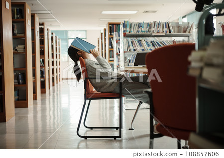 Asian student woman read books in library at university. Young girl stress tired have problem while study hard. Sadness concept Asian student woman read books in library at university. Young girl stress tired have problem while study hard. Sadness concept 108857606