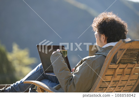 Autumn/winter close-up of a man working remotely in the mountains 108858042
