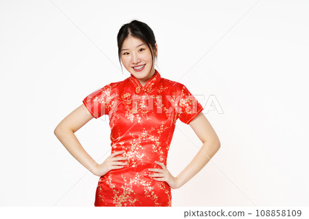 Asian woman wearing traditional cheongsam qipao dress standing with hands on waist and looking at camera isolated on white background.Happy Chinese new year. Asian woman wearing traditional cheongsam qipao dress standing with hands on waist and looking at camera isolated on white background.Happy Chinese new year. 108858109