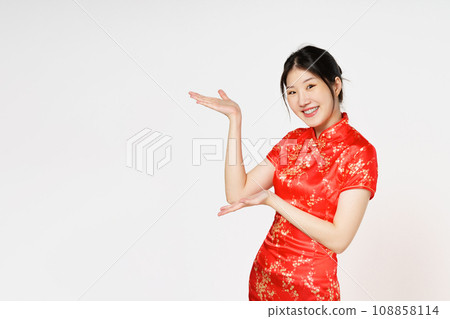 Happy Chinese new year. Asian woman wearing traditional cheongsam qipao dress with gesture of introduce isolated on white background. 108858114